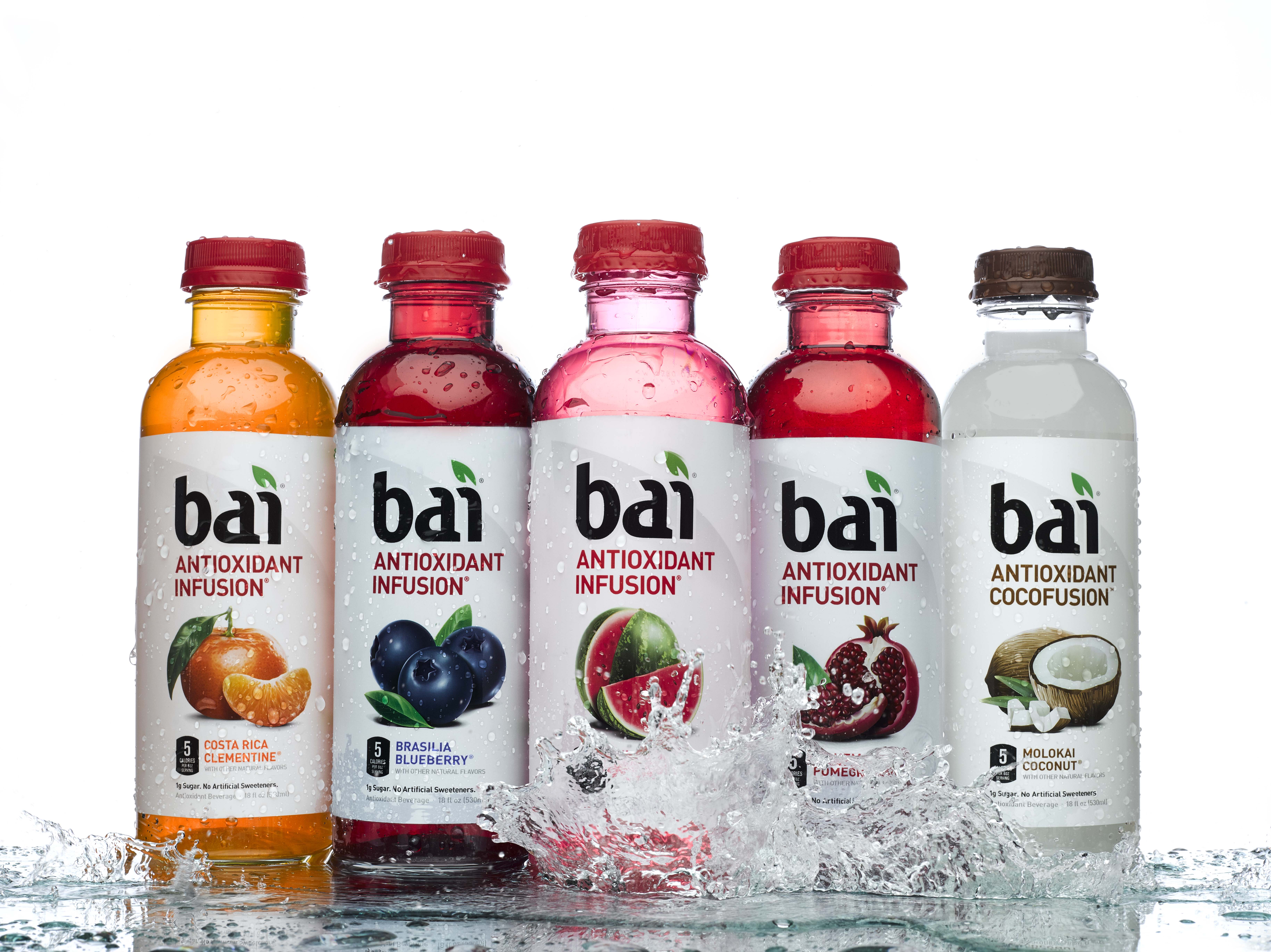 Sports drinks lined in a row with water splashing around it