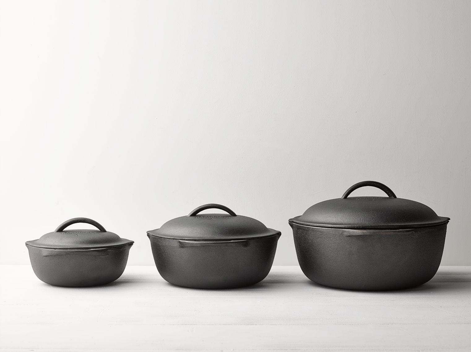 Cast iron pots in a straight line with soft shadows