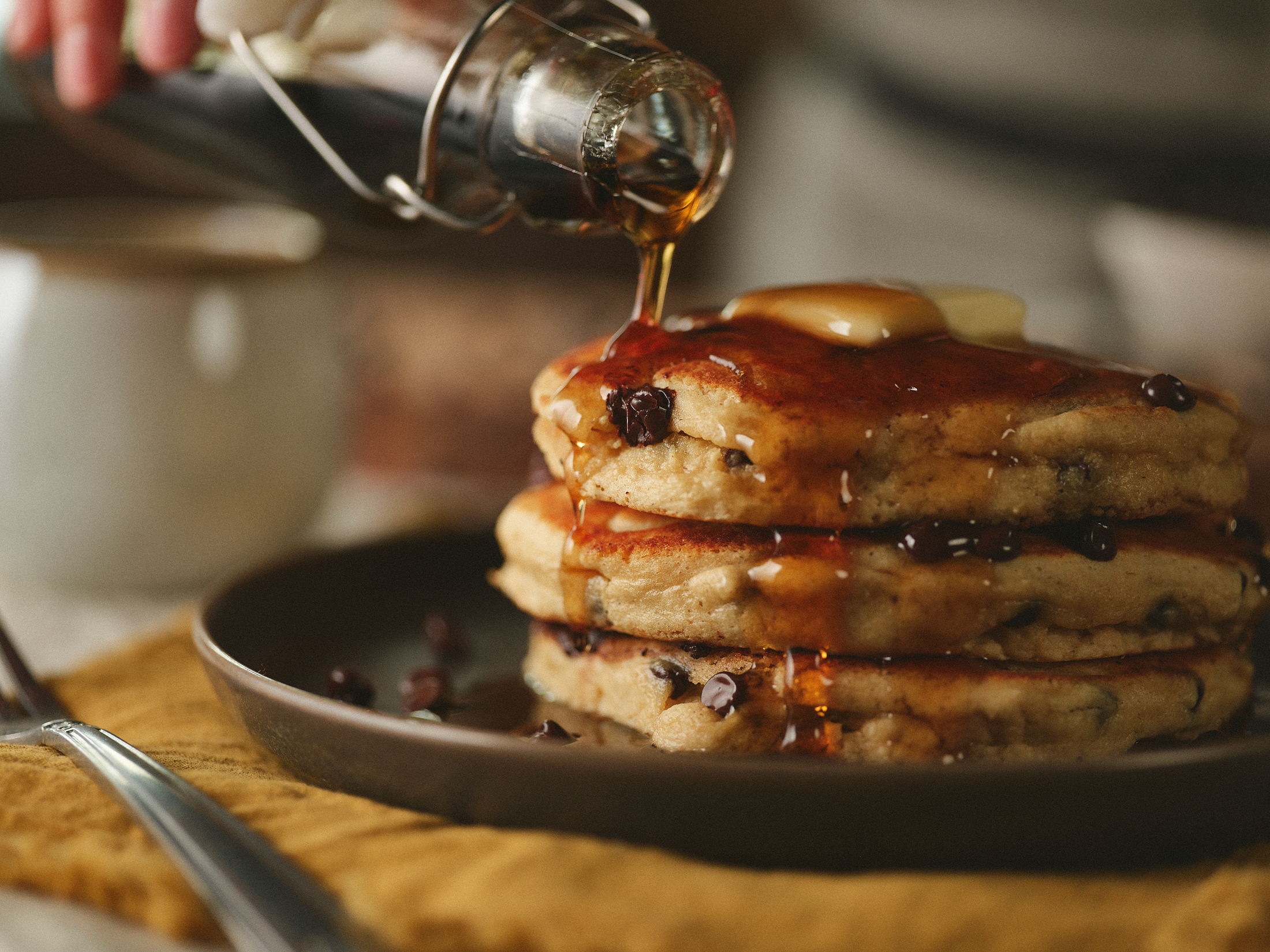 Kodiak Cakes with syrup poring onto pancakes 
