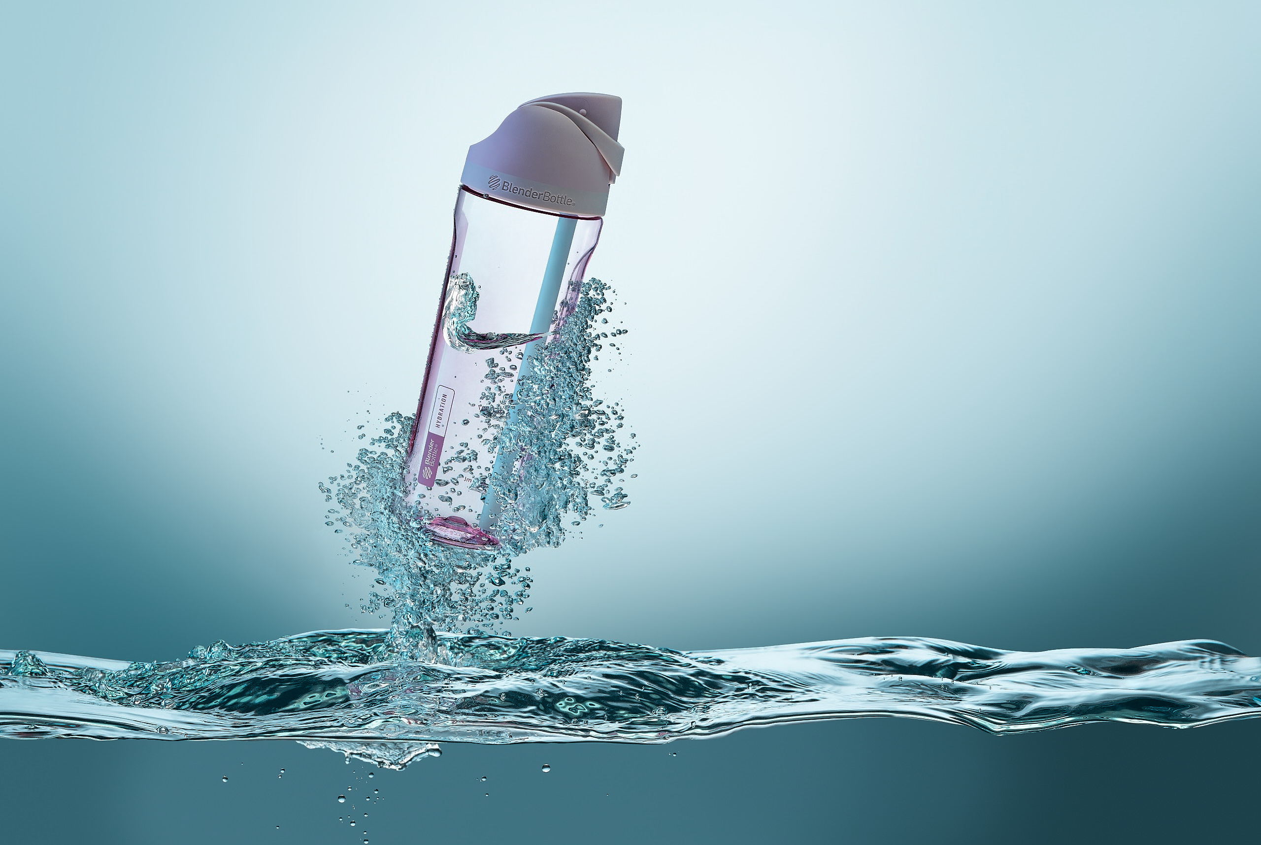 PINK SPORTS WATER BOTTLE SHOOTING OUT OF TEAL WATER WITH A BIG SPLASH 