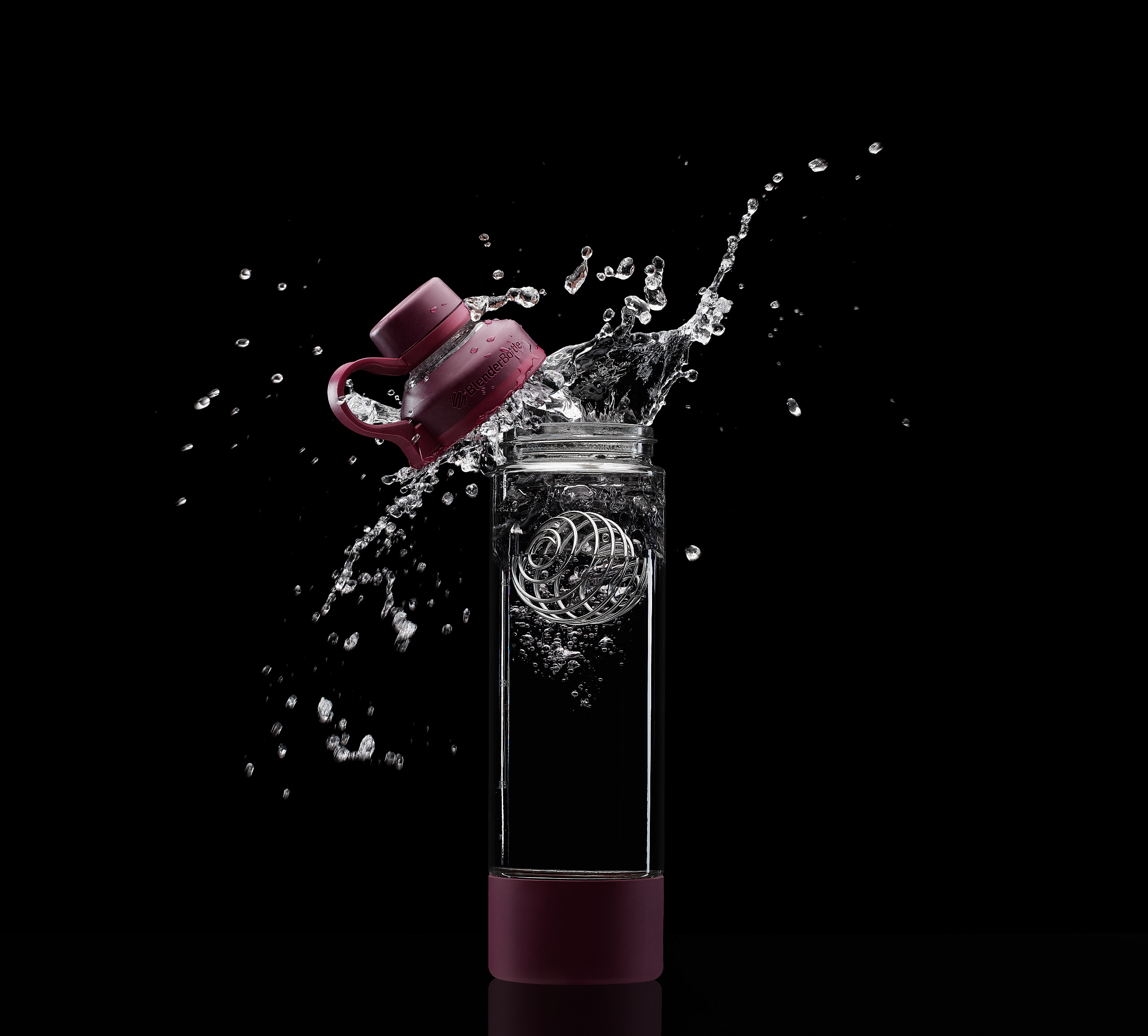 Object falling into water bottle with lid following behind and creating big splash