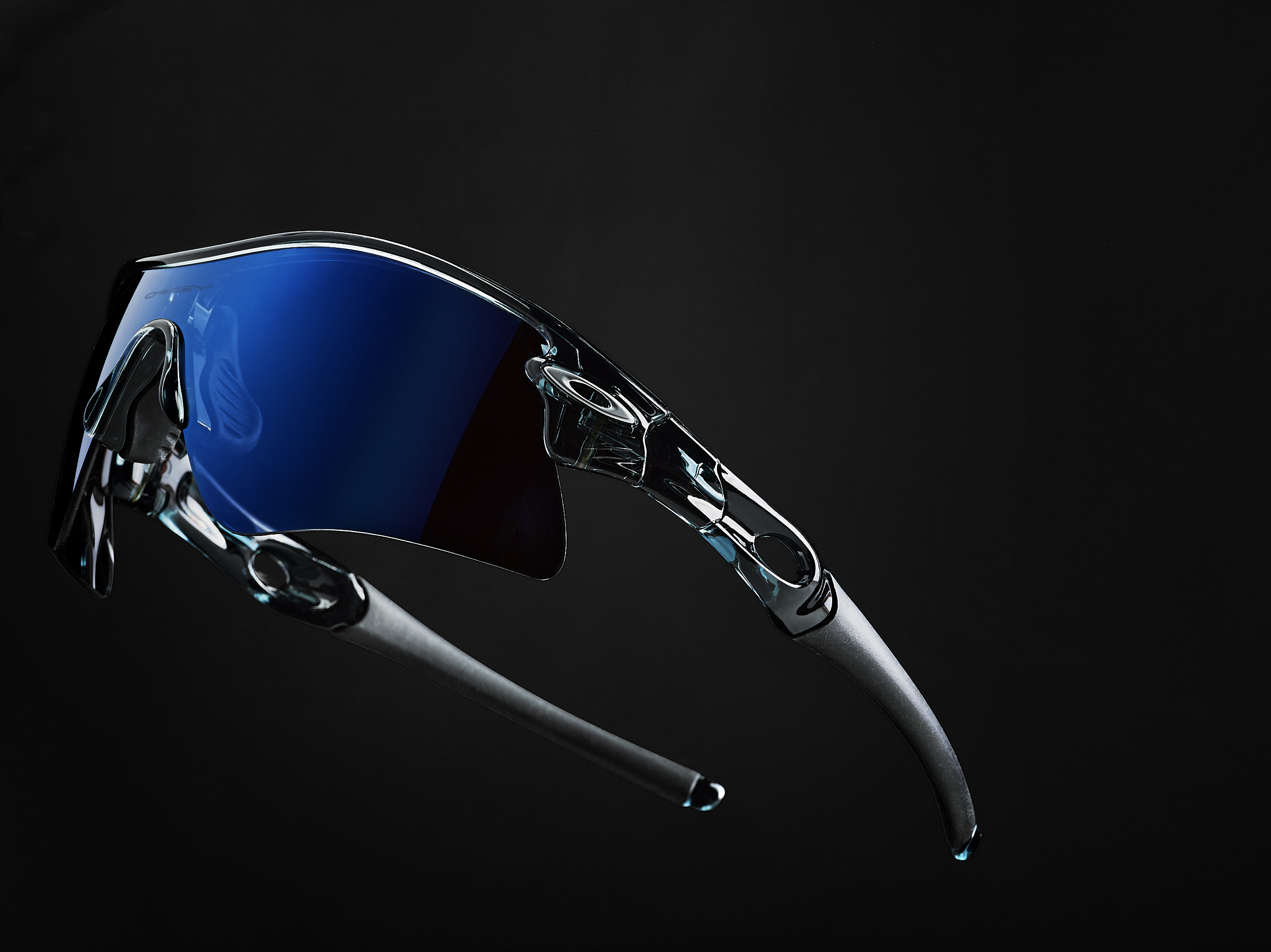 Still life shot of blue Oakley sunglasses on a black background fading dramatically Studio lighting